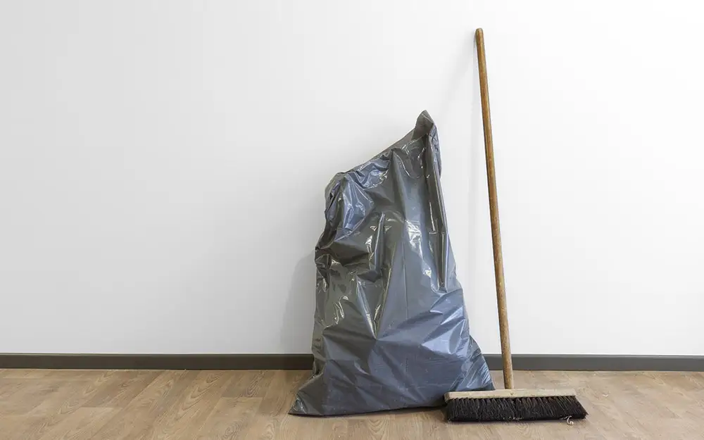 AM Raumbau Berlin GmbH Besen und Müllsack stehen in einem Neubau nach der Bauendreinigung